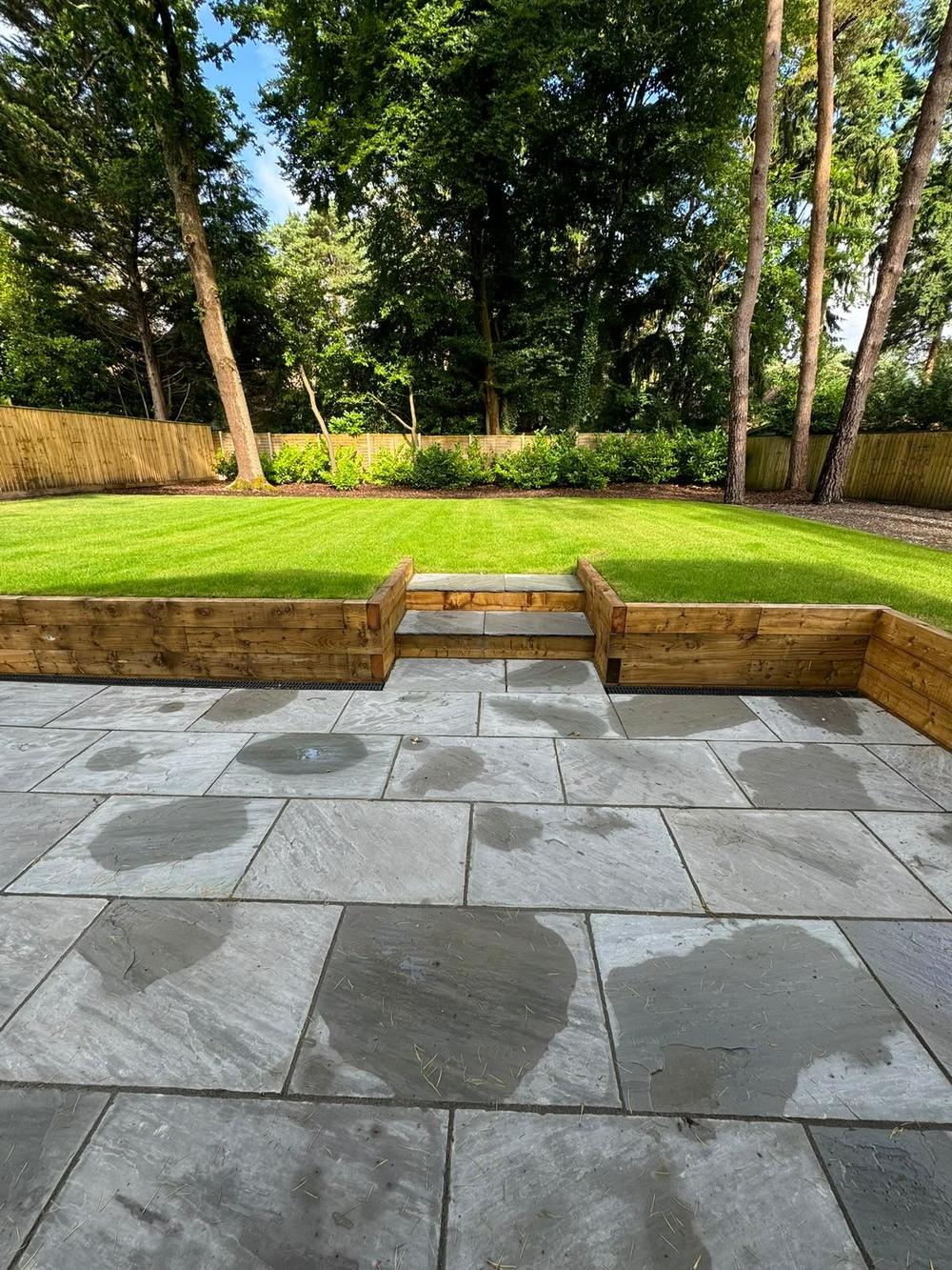 Sandstone patio with timber sleeper retaining wall